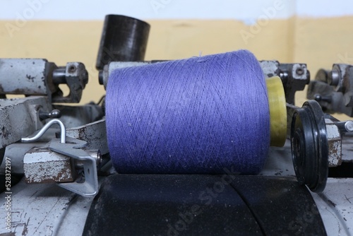 a spool with blue linen threads lying on a textile machine