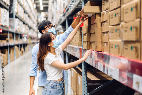 Asian two engineer team shipping order detail check goods and supplies on shelves with goods background inventory in factory warehouse.logistic industry and business export