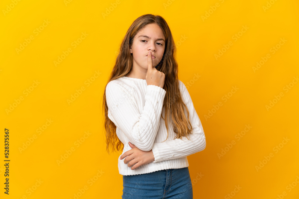 Child over isolated yellow background having doubts while looking up Child over isolated yellow background having doubts while looking up