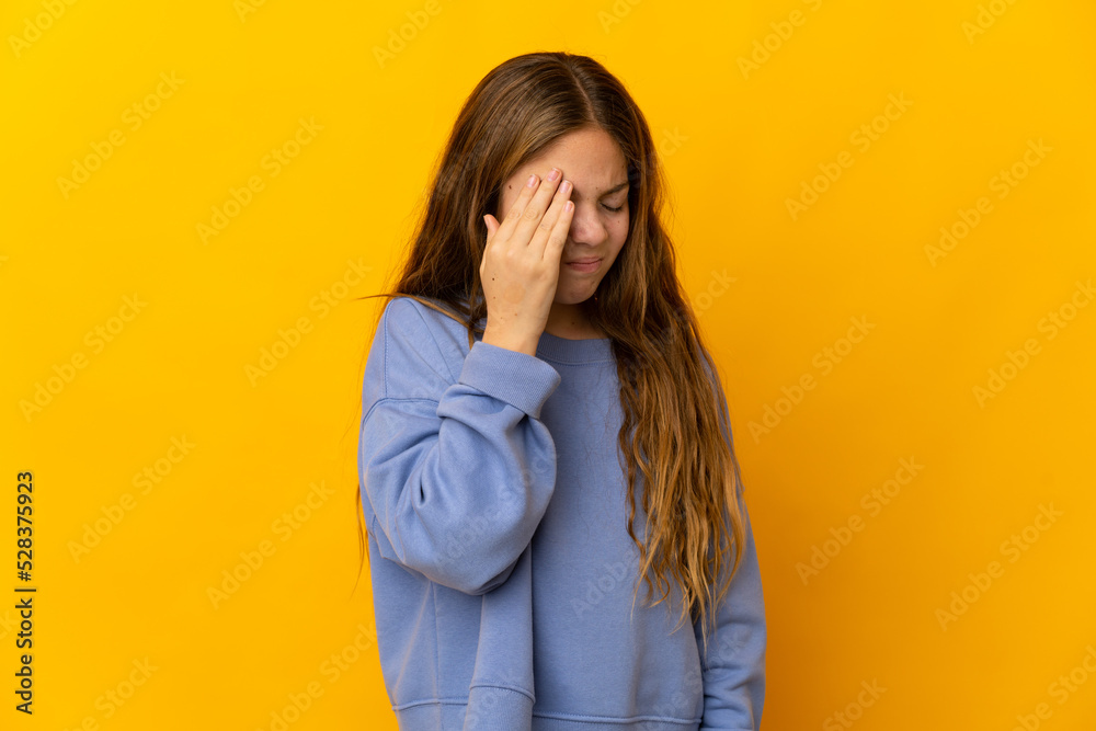 Child over isolated yellow background with headache