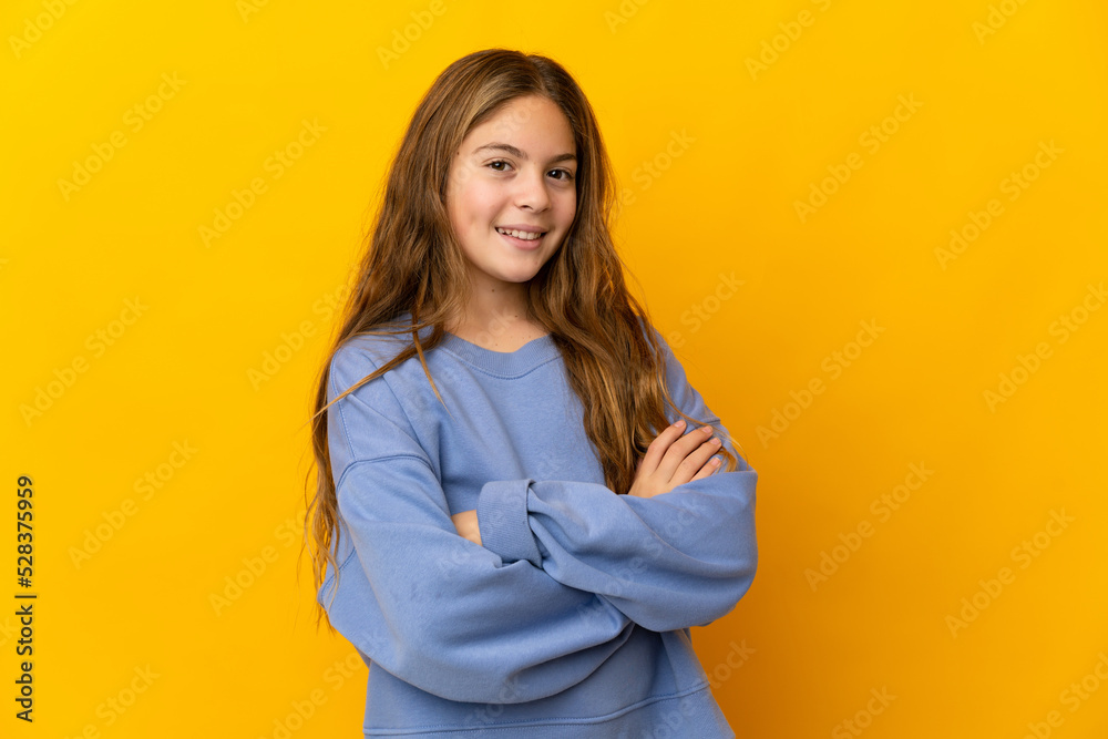 Child over isolated yellow background with arms crossed and looking forward Child over isolated yellow background with arms crossed and looking forward