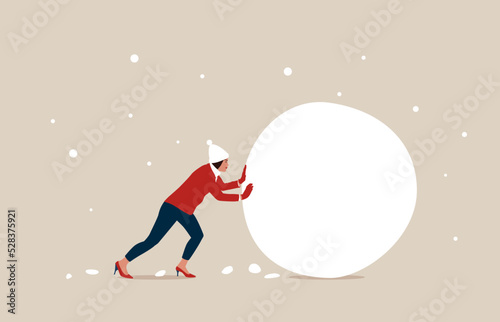 Businesswoman investor rolling large snowball build.  Snowball effect from small build up larger with potential risk, financial growth or mistake. 