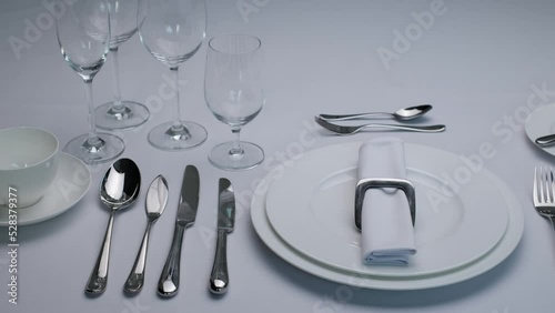 Classic serving tableware on the table, white plate fork and knife.