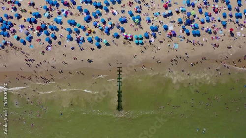 Aerial top view of umbrellas on sandy Rehoboth beach against sea waves in Delaware photo