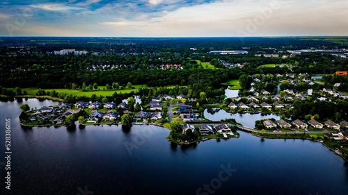 View of Heidemeer in city Heerenveen surrounded by river and greenery in Netherlands under blue sky photo