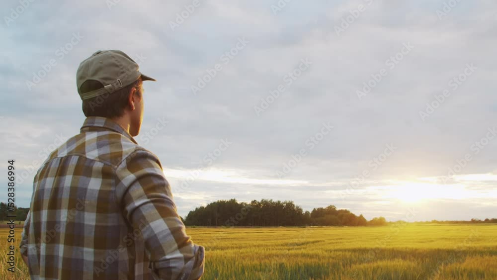 Farmer in front of a sunset agricultural landscape. Man in a countryside field. Country life, food production, farming and country lifestyle concept. Farmer in front of a sunset agricultural landscape. Man in a countryside field. Country life, food production, farming and country lifestyle concept.