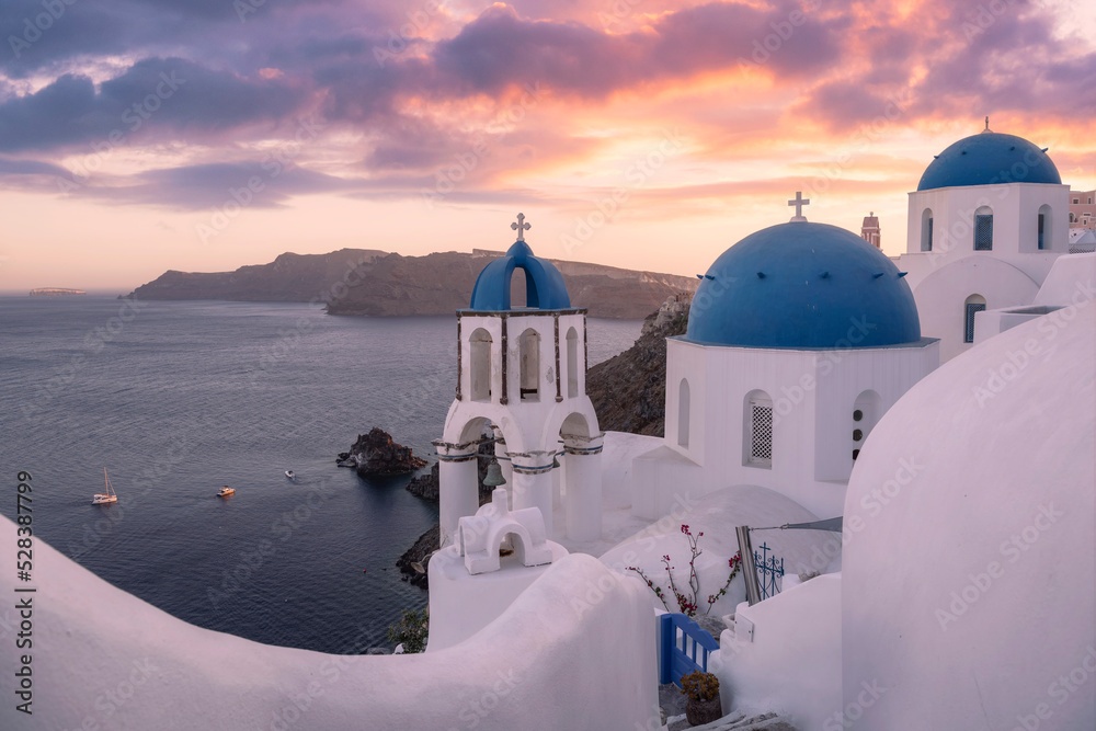 Scenic sunset view of the famous blue domes in Oia village, Santorini island, Greece