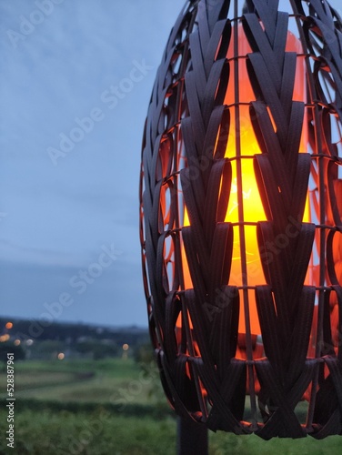 Vertical closeup of a lighting lantern placed outdoors photo