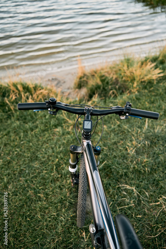 POV bike handlebar with a nature backdrop. Leisure time in summer evening concept.