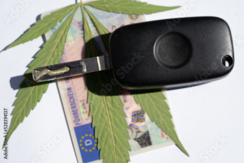 symbolisches Cannabisblatt mit Autoschlüssel und Führerschein