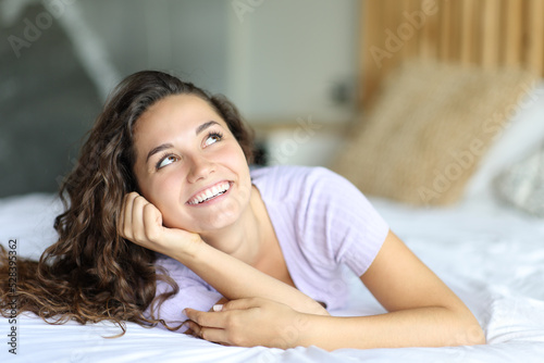 Happy woman looking at side on the bed photo