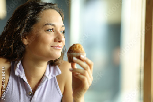 Woman holding a muffin in a restaurant