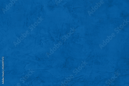 Saturated dark blue colored low contrast Concrete textured background. Empty colourful wall texture with copy space for text overlay and mockups. 2023, 2024 color trend