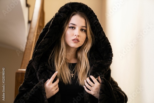 Portrait of a blonde pretty girl in a black heavy winter jacket