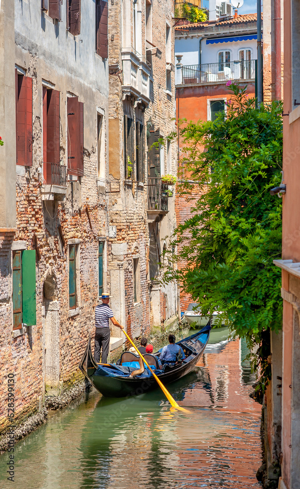 View on the narrow cozy streets of the canals with gondolas one of the symbols of Venice, Italy. Architecture and landmark of Venice.