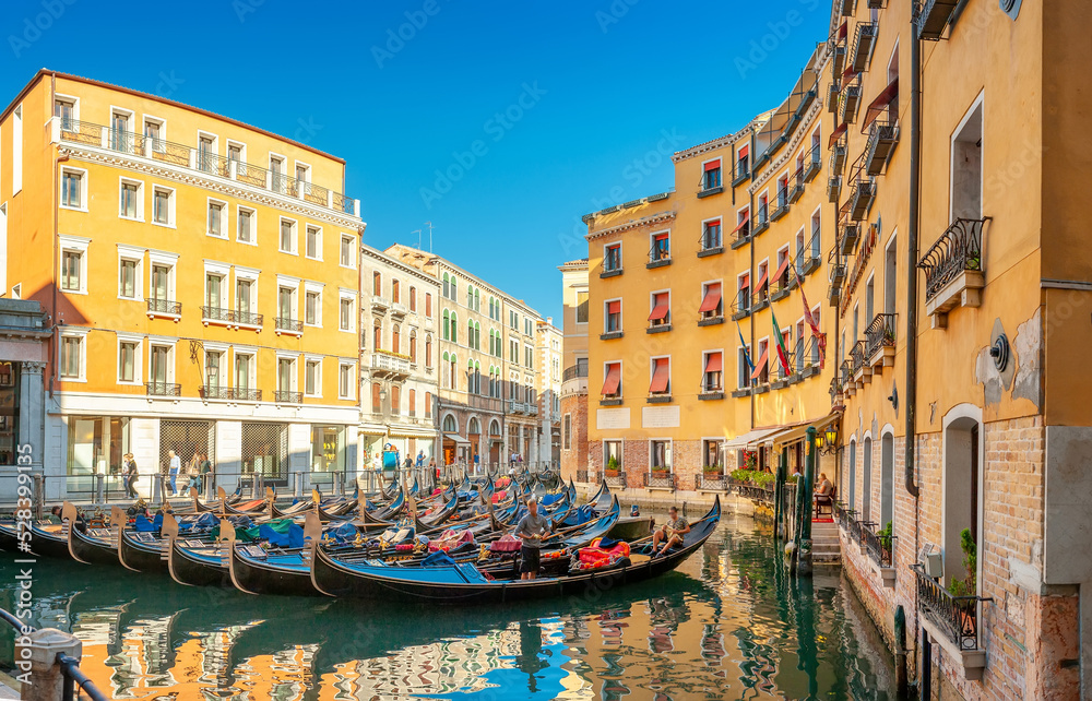 View on the narrow cozy streets of the canals with gondolas one of the symbols of Venice, Italy. Architecture and landmark of Venice.