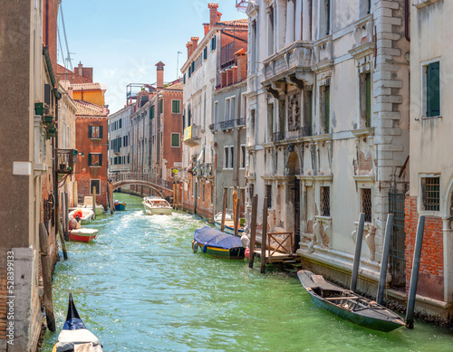 Obraz na płótnie View on the narrow cozy streets of the canals with parked boats in Venice, Italy. Architecture and landmark of Venice. w salonie