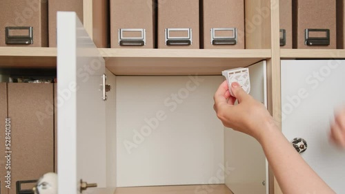 A woman installs a magnetic lock on the closet door to protect the child. Mother hands set up protection for baby safety