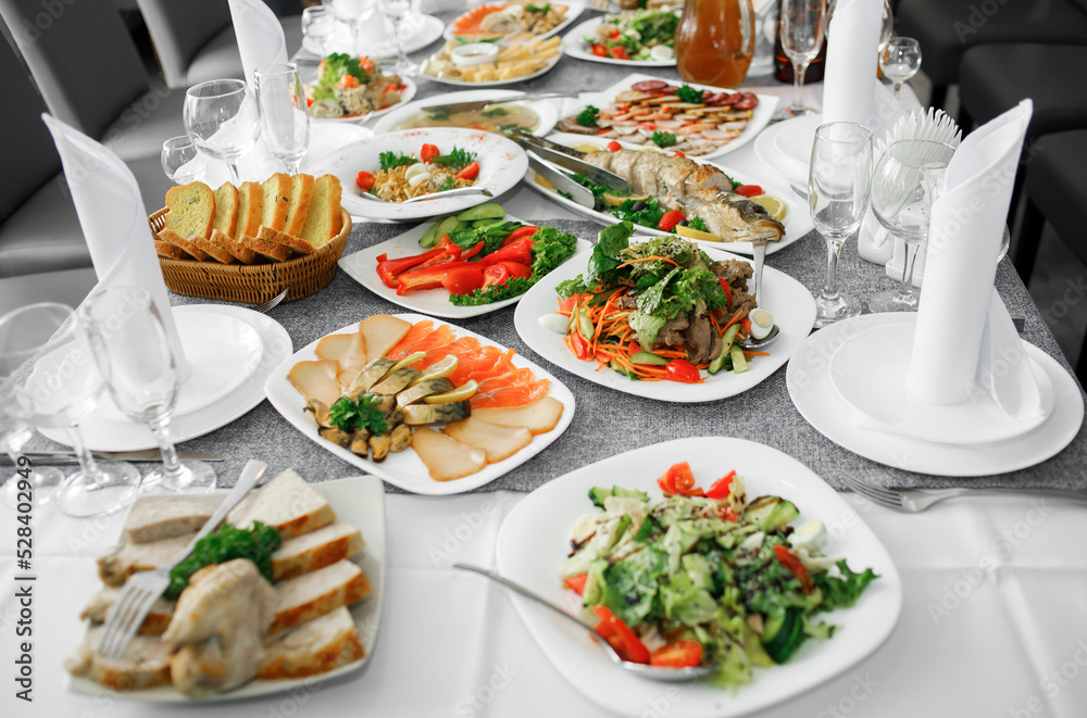 Fish dishes on the banquet table, logos, snacks, vegetables