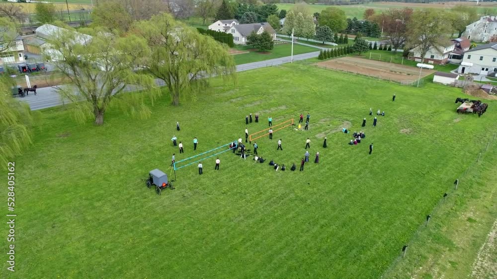 A Drone View of Amish Farmlands and Homesteads and Approaching Amish Teens Playing Volleyball on a Sunny Day A Drone View of Amish Farmlands and Homesteads and Approaching Amish Teens Playing Volleyball on a Sunny Day