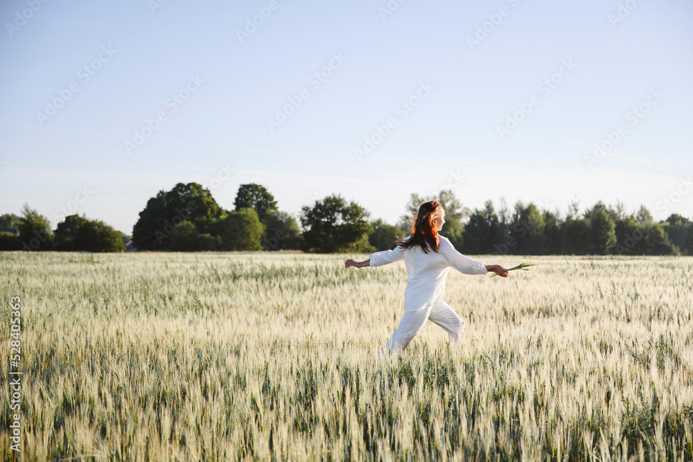 Carefree woman running in cornfield on sunny day Carefree woman running in cornfield on sunny day
