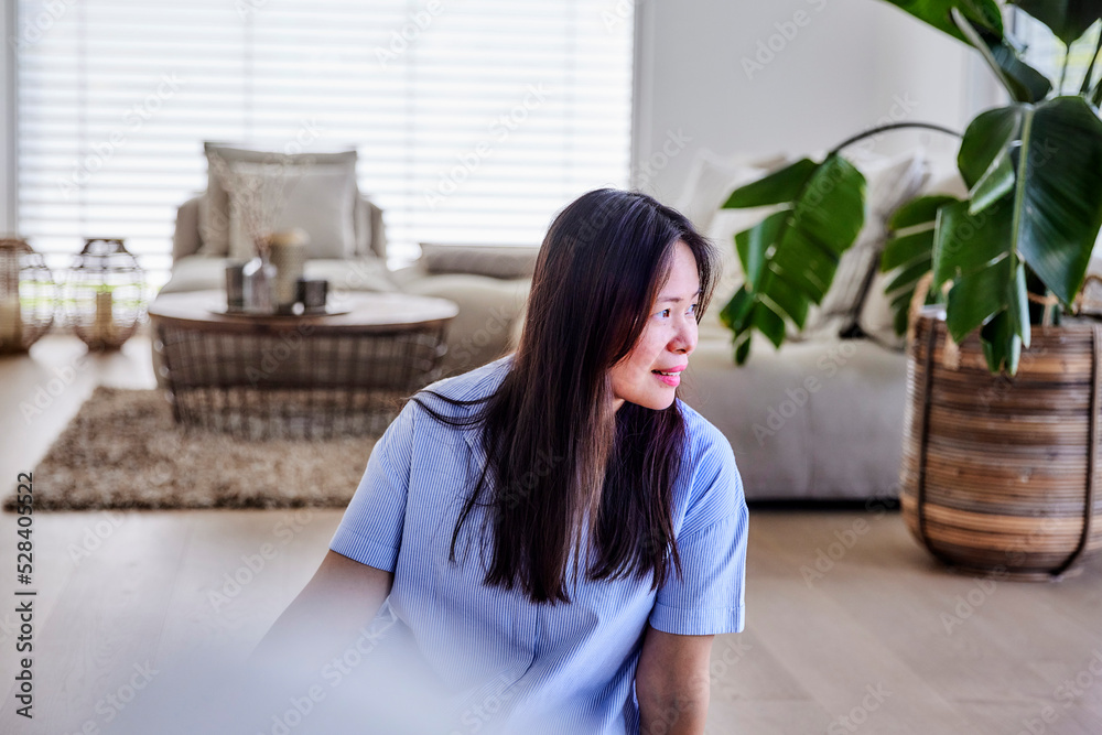 Smiling mature woman sitting on floor at home Smiling mature woman sitting on floor at home