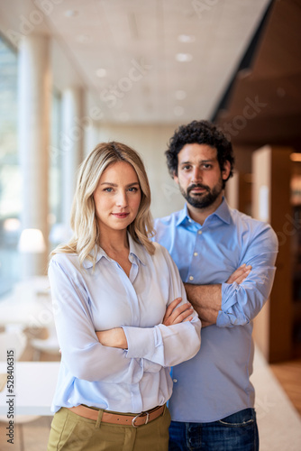 Confident professors with arms crossed in library photo