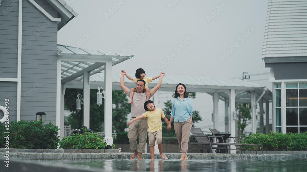 The family is happy because they can relax at a modern style holiday home.Husband and wife seem happy to be together with their children.The summer lifestyle is to take the family on vacation.