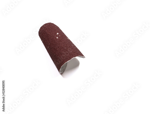 A piece of red sandpaper folded into a roll.