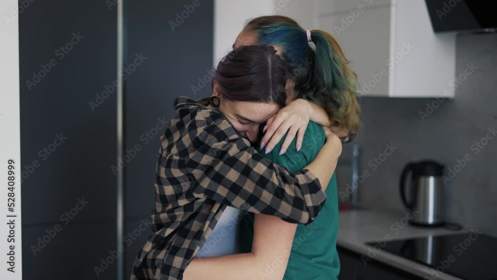 Loving same sex pregnant couple dancing in kitchen at home Loving same sex pregnant couple dancing in kitchen at home