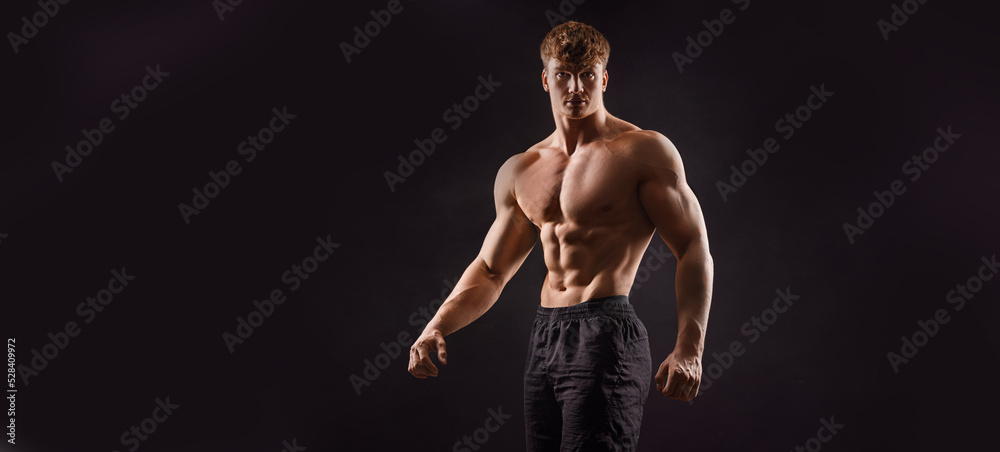  The torso of attractive muscular male body builder on black background.
