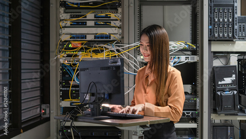 Billede på lærred A female programmer is working in a server room