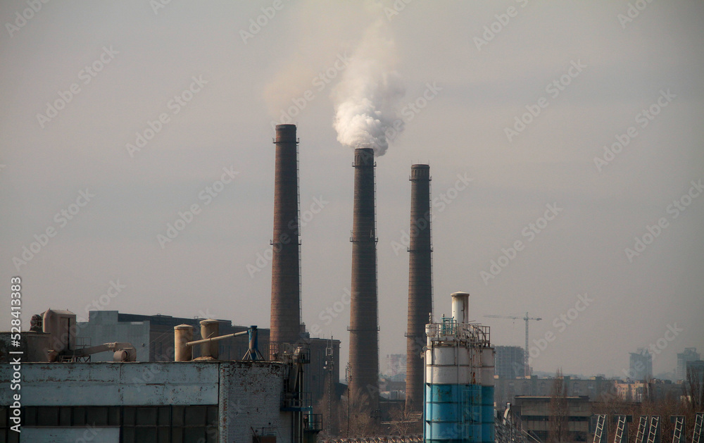 Huge industrial plant on the outskirts of the city pollutes the environment with emissions from smokestacks

