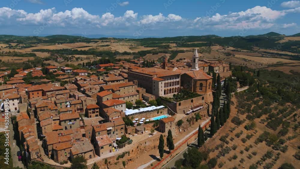 Famous tourist medieval Tuscany town Pienza in Val d'Orcia with old tower and church near iconic Siena and Florence, Italy close to Chianti wine and vinery area seen from above by drone as aerial view Famous tourist medieval Tuscany town Pienza in Val d'Orcia with old tower and church near iconic Siena and Florence, Italy close to Chianti wine and vinery area seen from above by drone as aerial view