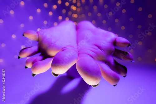 Bottom view of person fetish feet soles with long toenails toes in colorful lights