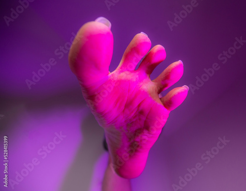 Person sole foot fetish stepping on camera surrounded with artistic colorful pink color