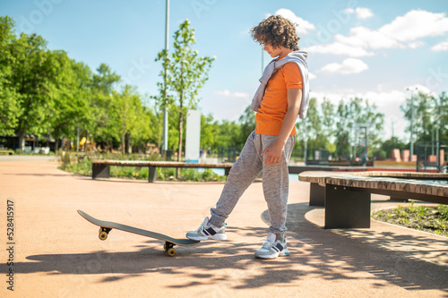 Fotografija Adolescent practicing a skateboarding trick in the park