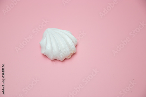 White meringues on pink background. French dessert prepared from whipped with sugar and baked egg whites. Greeting card with copy space