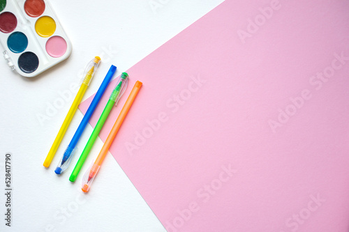 A set of stationery on a white and pink background  pens of different colors and watercolor