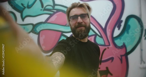 Portrait of a graffiti artist painting on glass. handheld camera