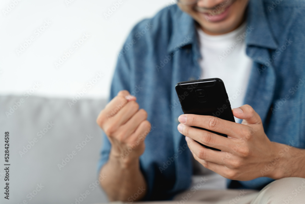 Happy excited man looking at mobile phone, man receiving good news using smartphone at home. Happy excited man looking at mobile phone, man receiving good news using smartphone at home.
