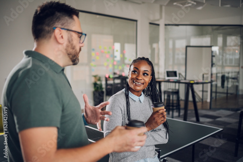 Multiracial colleagues talking and drinking coffee during a work break