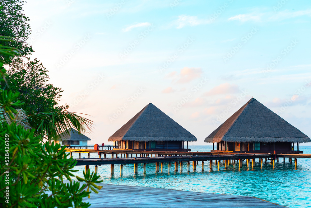 picturesque view of the water villas at sunrise in the Maldives, the concept of luxury travel