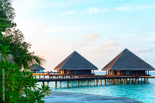 Fototapeta Naklejka Na Ścianę i Meble -  picturesque view of the water villas at sunrise in the Maldives, the concept of luxury travel