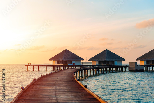 picturesque view of the water villas at sunrise in the Maldives, the concept of luxury travel © klavdiyav