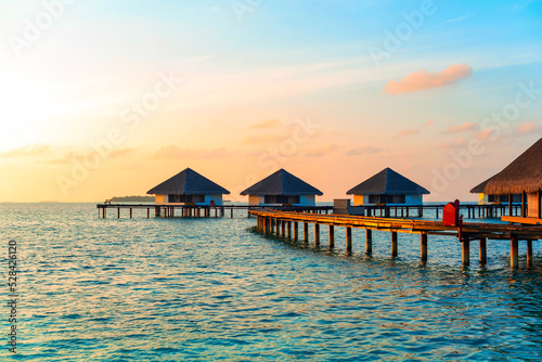 Fototapet picturesque view of the water villas at sunrise in the Maldives, the concept of