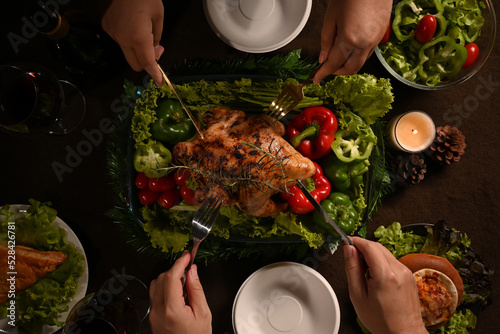 Group of friends or family enjoy eating roast turkey, Thanksgiving meal together. Thanksgiving celebration traditional dinner concept