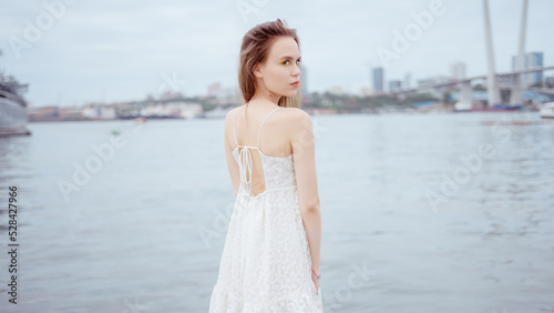 City portrait of beautiful young woman in white dress. © Vladimir Arndt