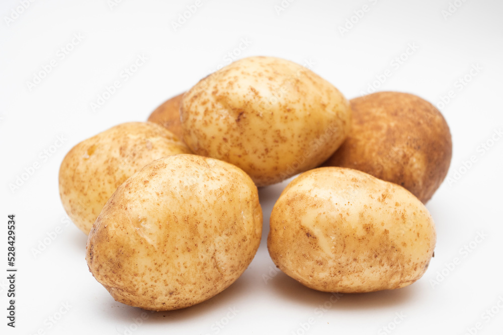 Fresh yellow raw potatoes on a white background Fresh yellow raw potatoes on a white background