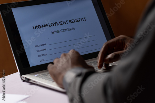 black person filling unemployment benefit form on a computer